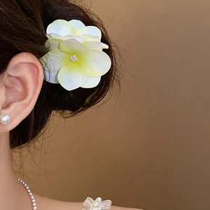 Dettaglio di un fermaglio per capelli a fiore in tessuto fresco indossato con eleganza
