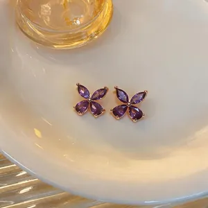 Close-up of purple teardrop zircon flower stud earrings with elegant rose gold plating