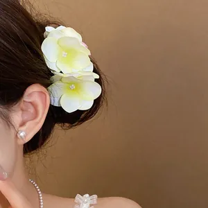 Dettaglio di elegante fermaglio per capelli a fiore in tessuto con perla su modella