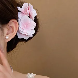 Vista dettagliata di un'elegante molletta per capelli a fiore in tessuto rosa su una modella