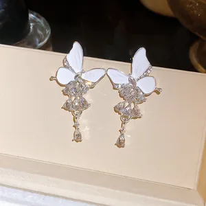Elegante silberne Schmetterlingsohrringe mit weißem Emaille und Kristallquasten.