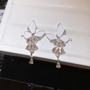 Makroaufnahme von eleganten Schmetterlingsohrringen mit Emaille und glitzernden Strasssteinen.
