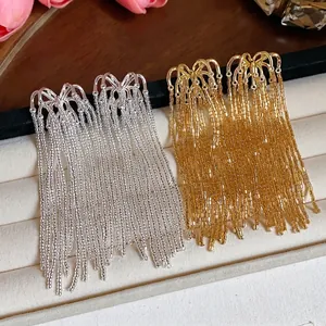 Exquisite gold and silver firework glass tassel earrings on a velvet jewelry display tray.