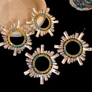 Gros plan sur des boucles d'oreilles géométriques avec strass colorés et cristaux