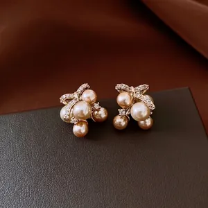 Elegant pearl cluster stud earrings with zircon bow accents for a luxury fashion look.