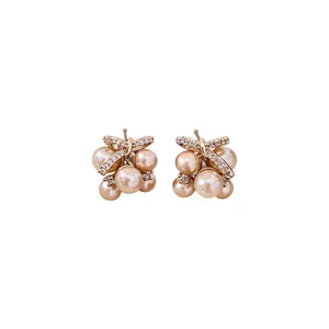 Elegant champagne pearl cluster stud earrings with sparkling zircon ribbon detail