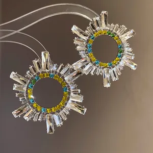 Vue macro détaillée des boucles d'oreilles géométriques avec des strass étincelants.