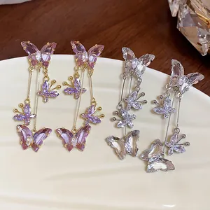 Vue détaillée de boucles d'oreilles papillon en zircon avec cristaux violets et clairs.
