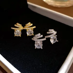 Detail showing cubic zirconia stud earrings in gold and silver finish on velvet box