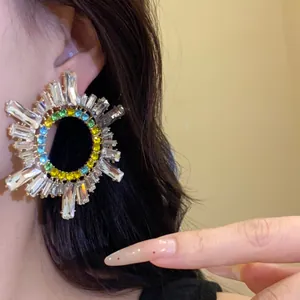Gros plan de boucles d'oreilles géométriques circulaires avec des strass colorés