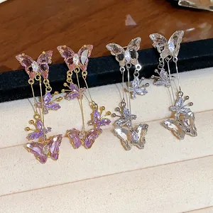 Gros plan sur des boucles d'oreilles papillon en zircon rose et blanc transparent