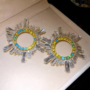Détail de boucles d'oreilles rondes étincelantes avec des strass en cristal colorés