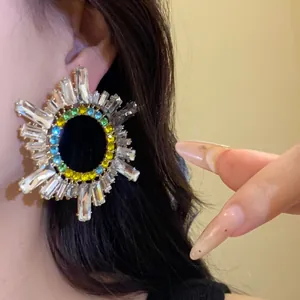 Vue détaillée des boucles d'oreilles soleil avec cristaux colorés et pierres baguette