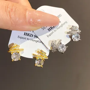 Close-up detail of luxury round zirconia stud earrings with sparkling spiral design