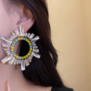 Détail d'une boucle d'oreille géométrique en cristal avec des pierres multicolores
