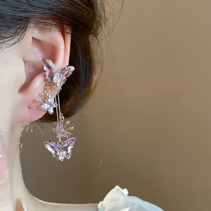 Gros plan élégant d'un earcuff papillon en zircon violet porté sur l'oreille