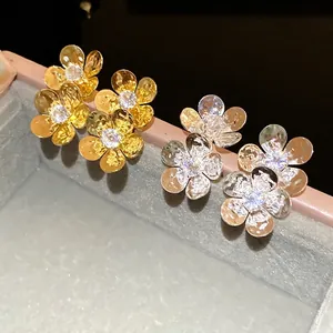 Vintage hammered flower stud earrings with sparkling zircon centers in gold and silver tones.