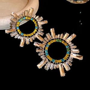 Détail de boucles d'oreilles soleil avec baguettes claires et cristaux colorés élégants
