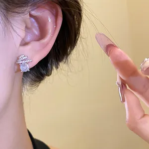 Close-up of a sparkling round zirconia ear stud with minimalist silver design on ear.