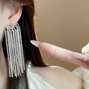 Detailed macro shot of long silver metal fringe tassel earrings worn for a luxury fashion look