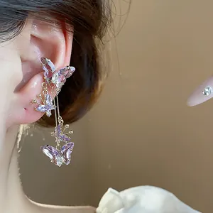Détail en gros plan d'élégantes boucles d'oreilles papillon en zircon violet sur l'oreille