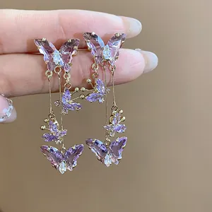 Vue rapprochée d'exquises boucles d'oreilles clips papillon en zircon violet