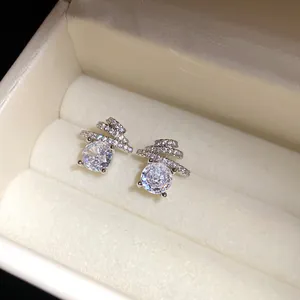 Close-up of elegant silver stud earrings with round zircon and spiral crystal detail