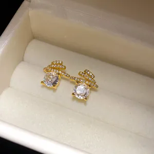 Close-up detail of luxury gold-plated round stud earrings with brilliant sparkling zircon