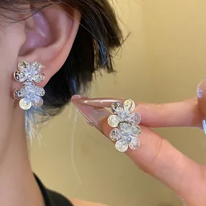 Detailed close-up of sparkling zircon flower stud earrings featuring a vintage silver design.