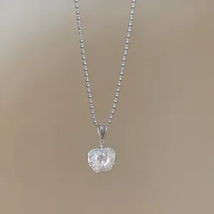 Dettaglio di una collana con ciondolo a forma di mela d'argento con zirconi scintillanti