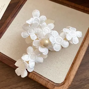 Elegant white fabric flower hair claw clip with a central gold pearl accent for women