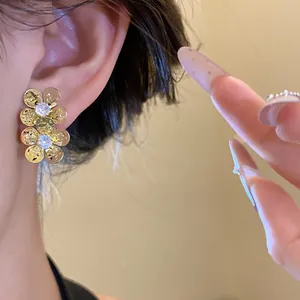 Close-up detail of vintage golden flower stud earrings featuring sparkling clear zircon centers