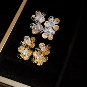 Close-up view of elegant vintage zircon flower stud earrings in gold and silver.