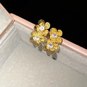 Detailed view of vintage gold flower earrings with sparkling cubic zirconia stones
