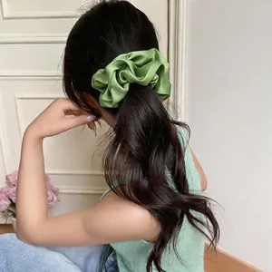 Grüner Satin Haargummi im Forest-Stil für Damen, gezeigt an einem niedrigen Pferdeschwanz