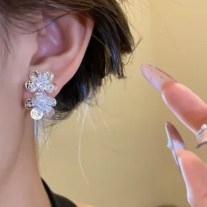 Detail showing vintage silver needle stud earrings with elegant zircon flower design