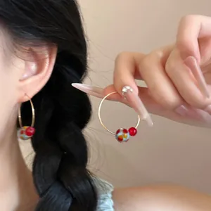 Detailed macro view of vibrant colorful glass bead hoop earrings with an elegant gold finish