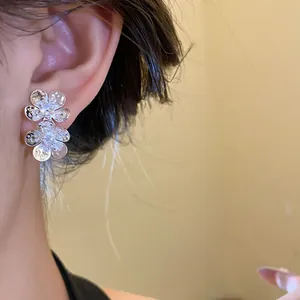 Macro view of vintage silver flower stud earrings with zircon centers and hammered finish