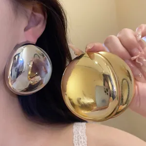 Macro view of metallic high-shine oval stud earrings in gold and silver finishes.