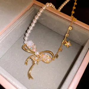 Elegant vintage bow necklace with pearls, zircon flower, and bee charms in a gift box.