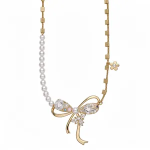 Elegant vintage bow pendant necklace featuring zircon stones and white pearls on gold chain