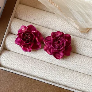 Elegant dark pink resin rose stud earrings with silver needles in a jewelry box