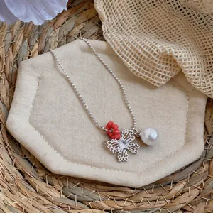 Detailed view of a silver-tone necklace featuring zircon butterfly and white pearl
