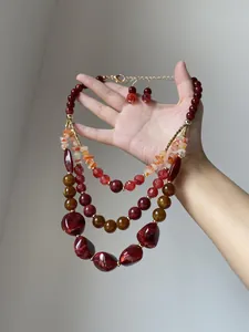 Dettaglio che mostra la trama della collana di perle multistrato in resina rossa e agata