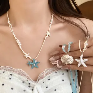 Dettaglio di ciondoli a tema marino con stelle marine e conchiglie su una collana