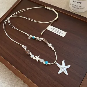 Vista dettagliata di una collana di perle di conchiglia fatta a mano con stella marina