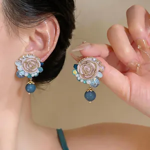 Close-up of French retro resin flower stud earrings with elegant blue bead charms
