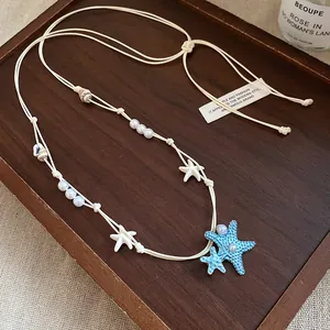 Collana da spiaggia fatta a mano con ciondoli a stella marina blu e perle di conchiglia