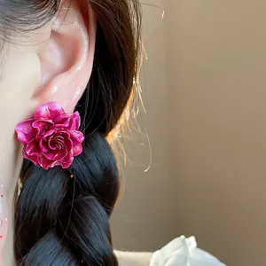 Close-up detail of a magenta rose-shaped resin flower stud earring worn on the ear