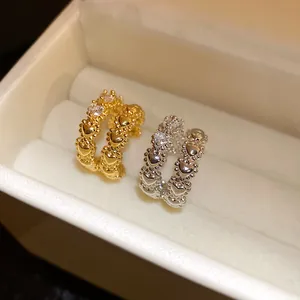 Close-up of gold and silver double-layered heart ear cuffs with zircons in a jewelry box